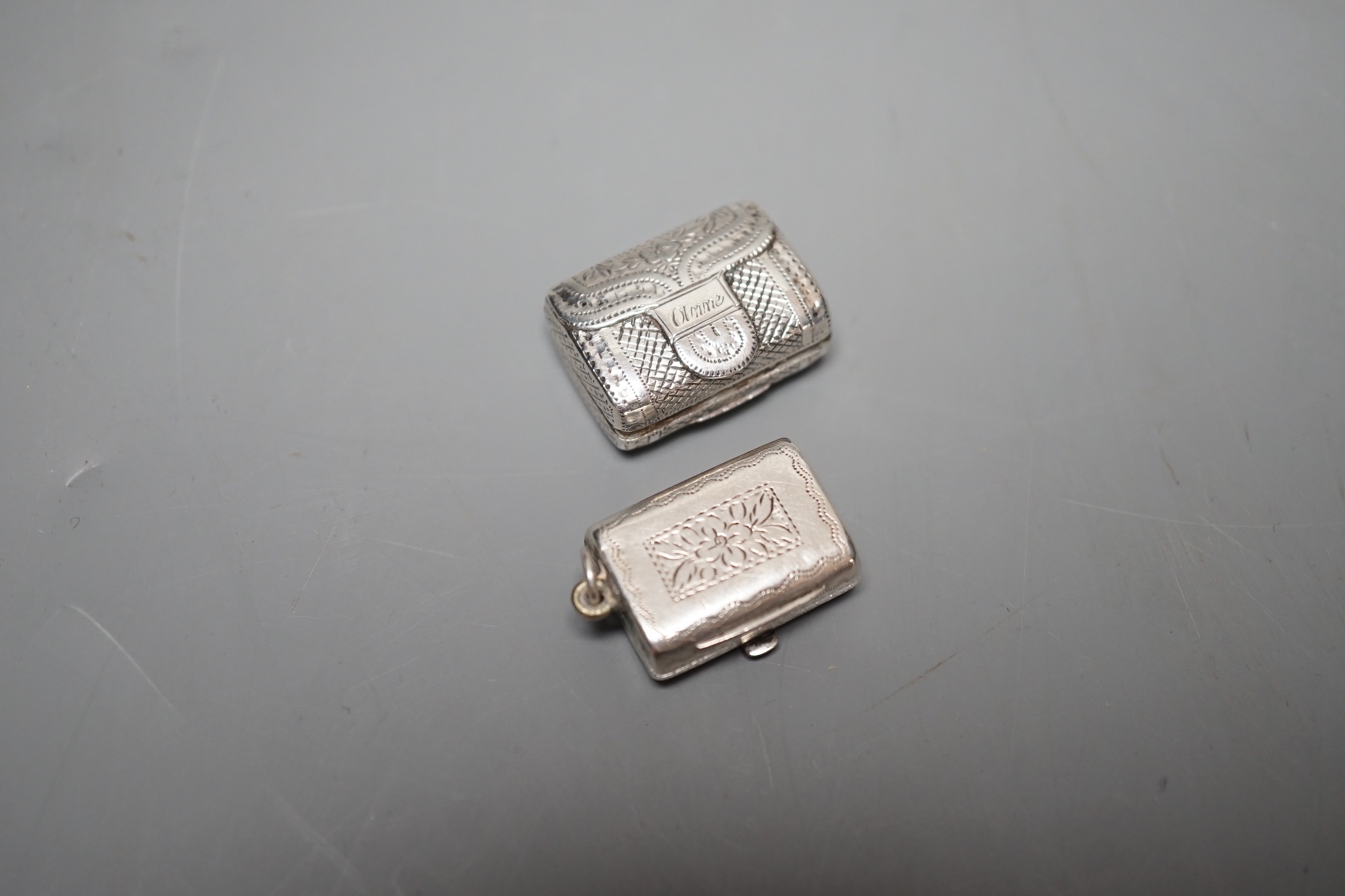 A George III engraved silver vinaigrette, modelled as a handbag, John Lawrence & Co, Birmingham, 1817, 23mm engraved 'Anne' and a similar William IV silver vinaigrette, Thomas Simpson Jn, Birmingham, 1831, 21mm.